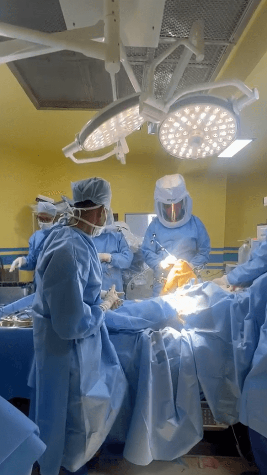 The surgical team at work under theatre lights during a robot-assisted knee replacement